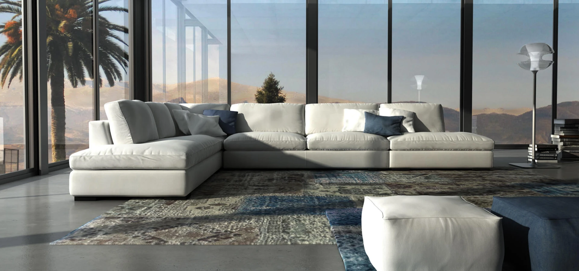 Sofá Izu modular en blanco con chaise longue, en un salón acristalado con vistas a palmeras